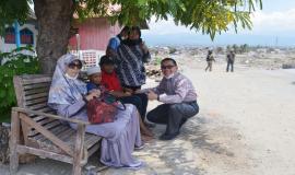 Plt. Direktur Pengendalian SDPPI Nurhaedah dan Kabag Umum dan Kepegawaian Hasyim Fiater berbincang dengan anak-anak di sekitar Balaroa, Palu (26/10).