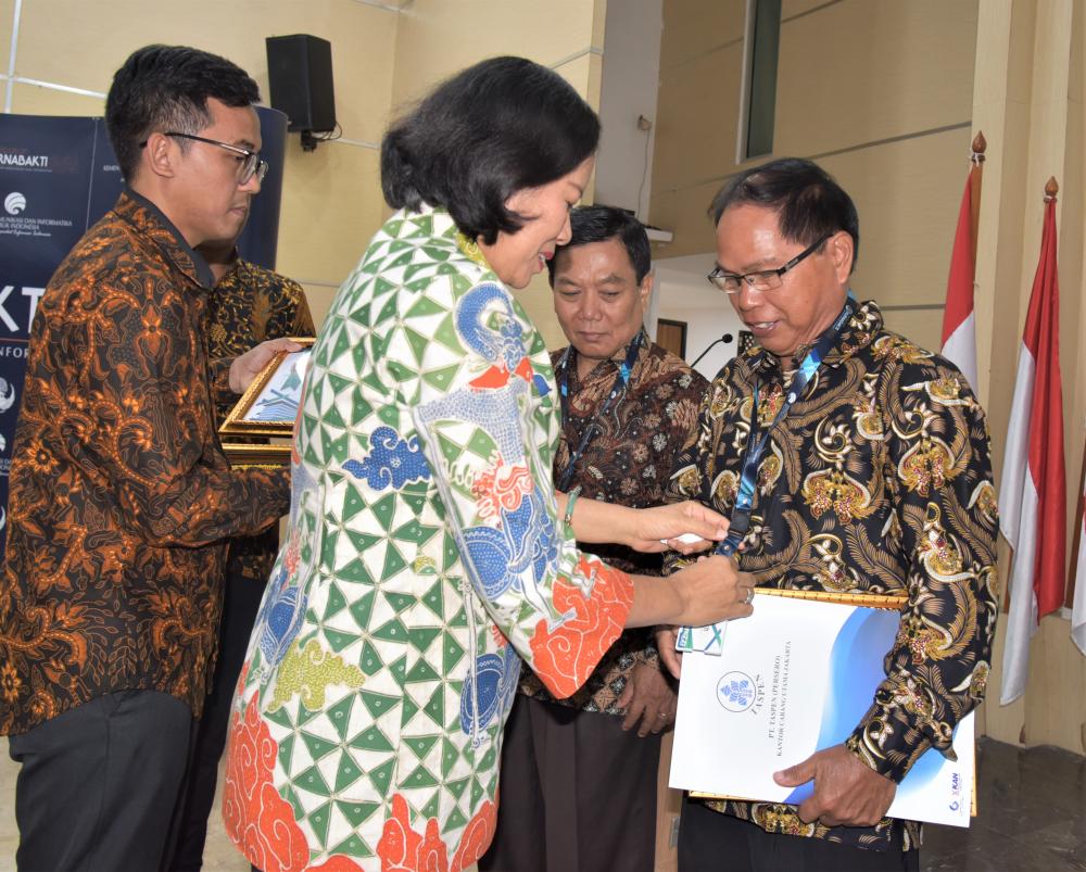 Sekjen Kemkominfo Niken Widiastuti memberikan Piagam Penghargaan kepada Marthin Pengemanan, Kasubag TU Loka Monitor Merauke pada pelepasan purnabhakti di Ruang Serba Guna Kemkominfo, Jumát (29/3/2019)