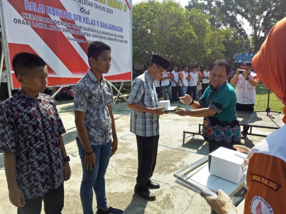 Ka Balmon Banjarmasin, Mujiyo, menyerahkan piagam penghargaan dan cinderamata terhadap peserta tertua UNAR, yaitu Anang Rifai  (79 tahun) dan termuda Muhammad Thoriqul Huda (13 tahun) di SMUN I Kandangan Kabupaten Hulu Sungai Selatan, Minggu (6/10/2019).