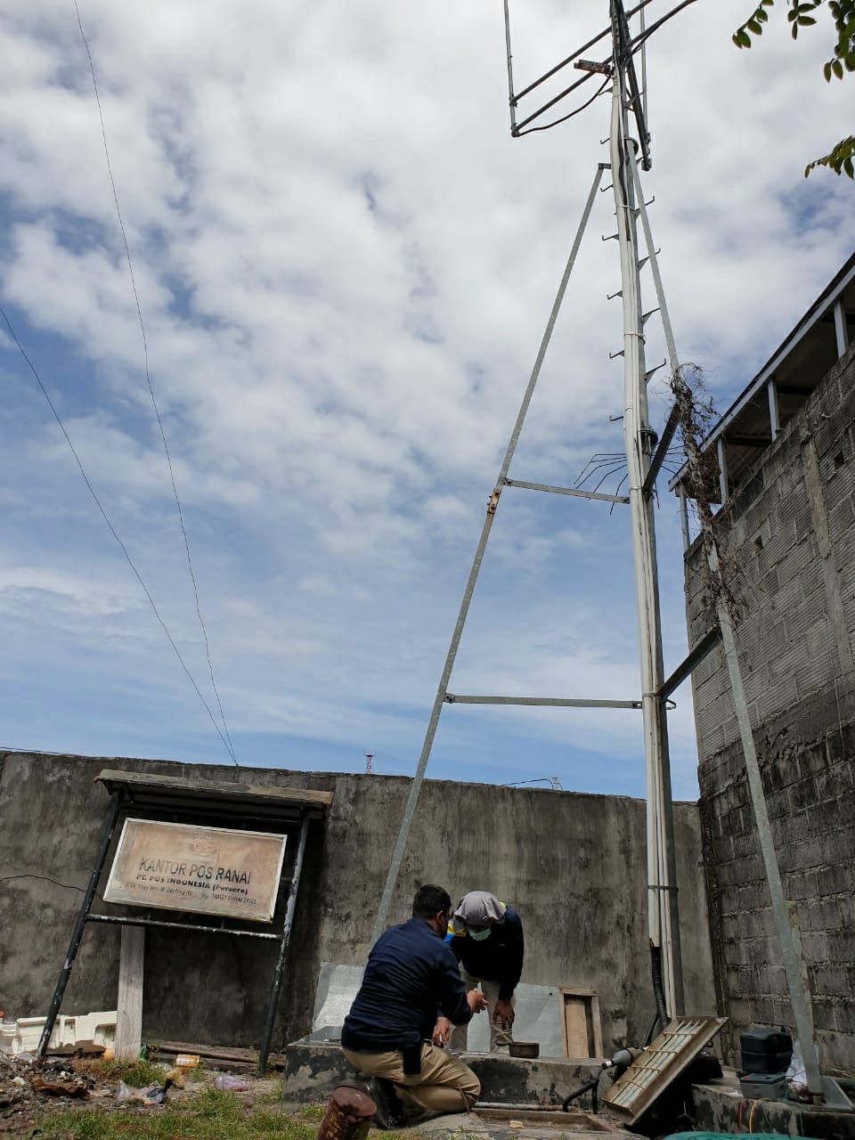 Dua petugas SFR Kelas II Batam sedang melakukan perawatan dan instalasi ground system pada perangkat Stasiun Monitoring Frekuensi Radio Transportable Site Rinai di Kabupaten Natuna, Riau. Jumat (19/02/2021)