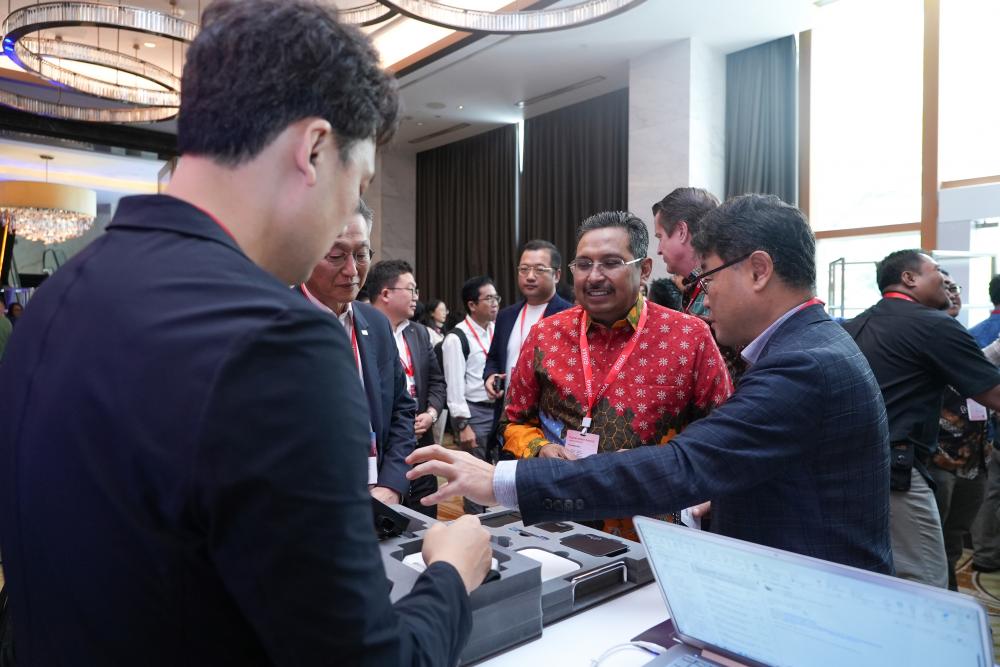 Dirjen SDPPI Ismail menyimak penjelasan yang disampaikan oleh delegasi dari Jepang dalam kegiatan Digital Nation Summit 2023, Rabu (6/12/23).