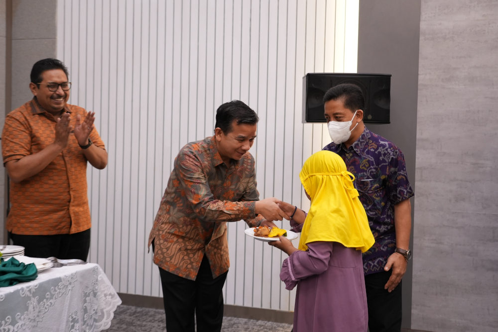 Kepala BBPPT Syaharuddin menyerahkan potongan tumpeng kepada salah satu anak Panti Asuhan disaksikan Dirjen SDPPI Ismail dalam tasyakuran di Gedung baru BBPPT, Jum'at (27/01/2023).